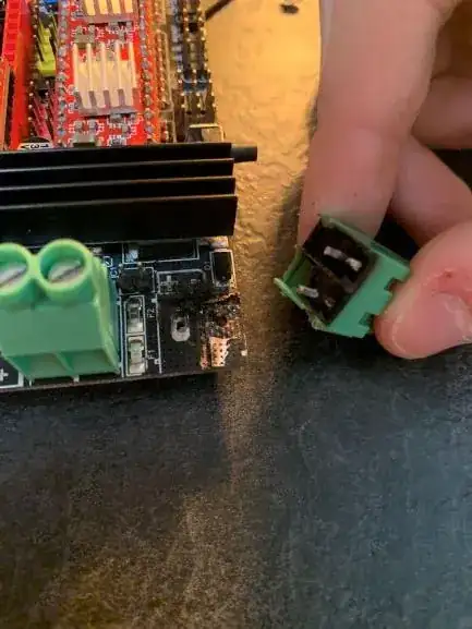 Top side of PCB and underside of power screw terminals, showing burning